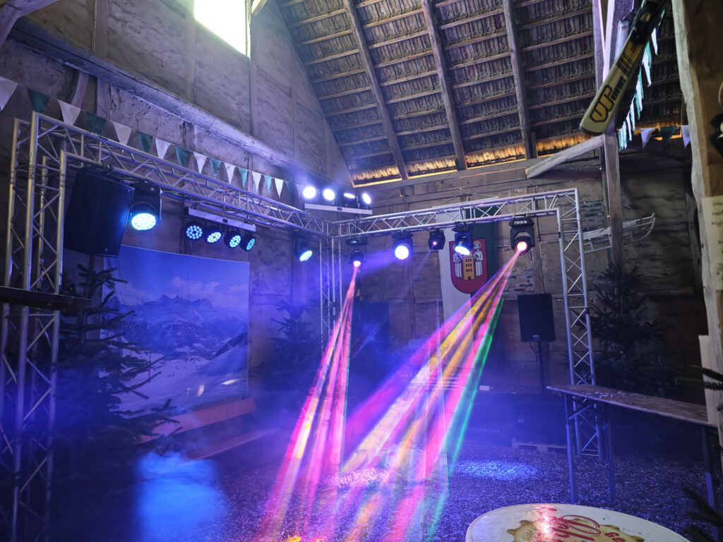 Traversenaufbau mit farbigen Lichtstrahlen in einer Scheune