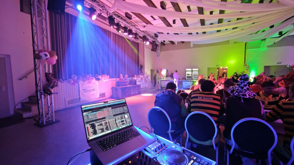 Blick vom DJ- und Technikplatz in einen bunt beleuchteten Veranstaltungssaal
